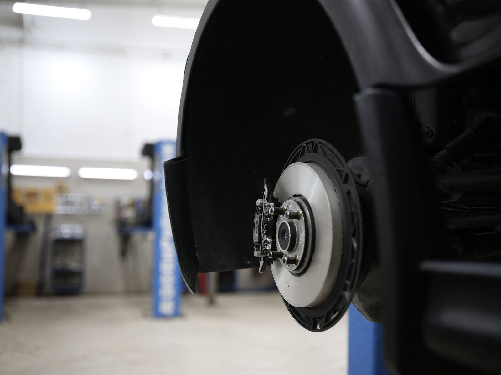 A car wheel and brake disc in a shop