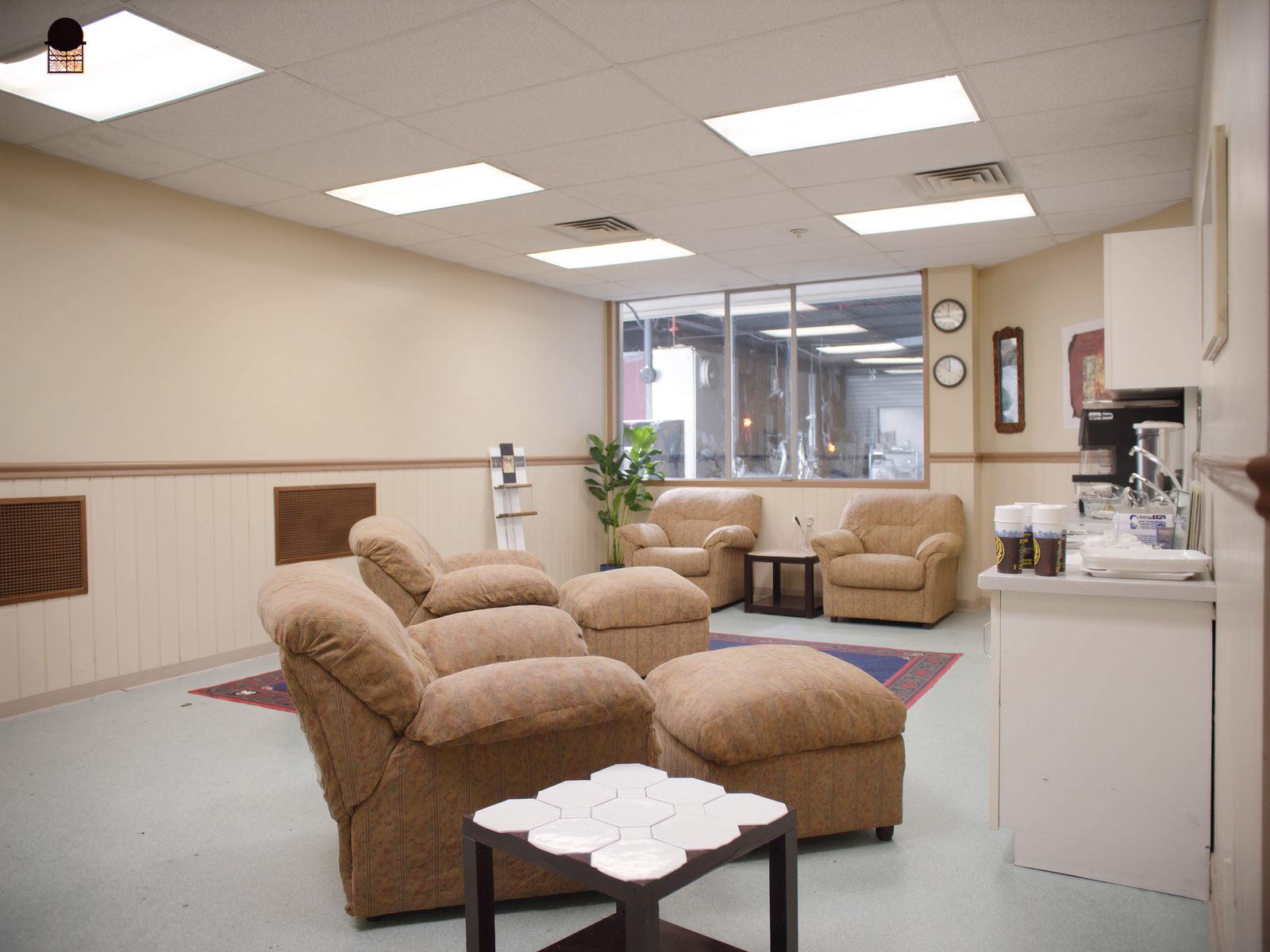 A clean customer waiting area with a coffee station