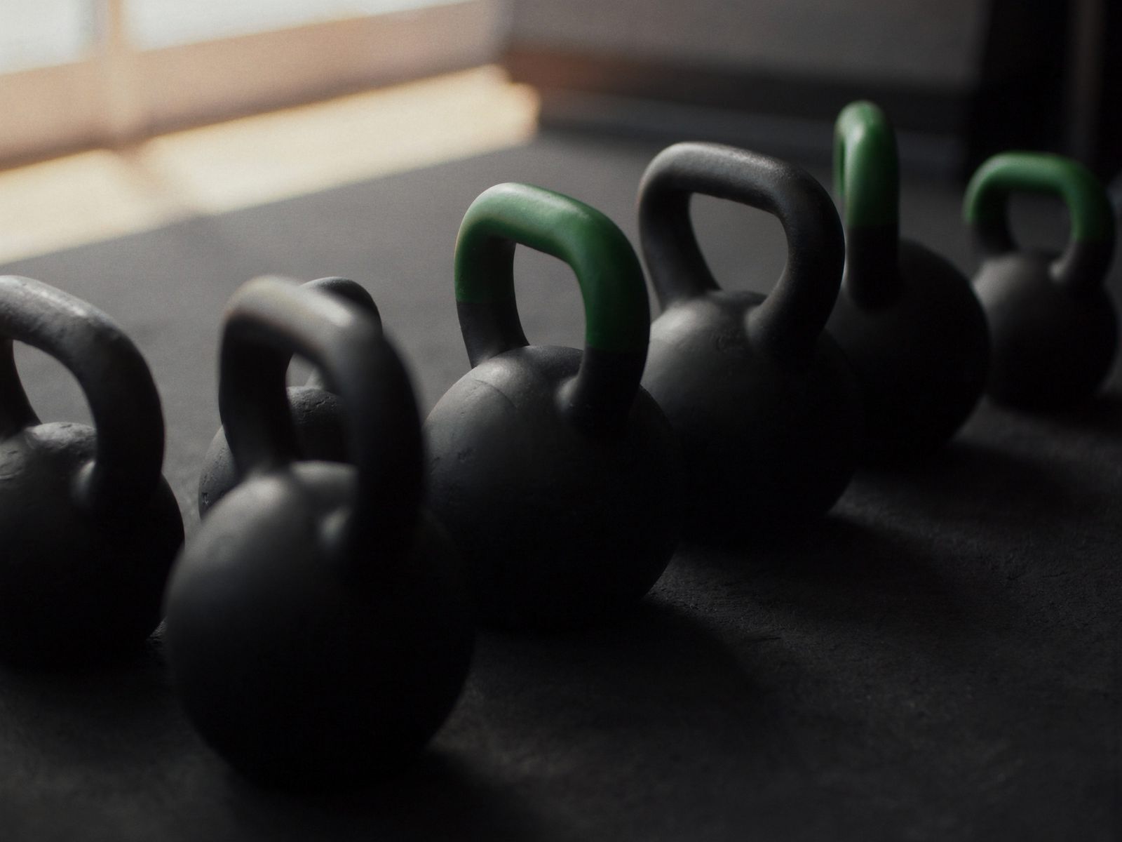 A row of kettlebells on a rubber floor