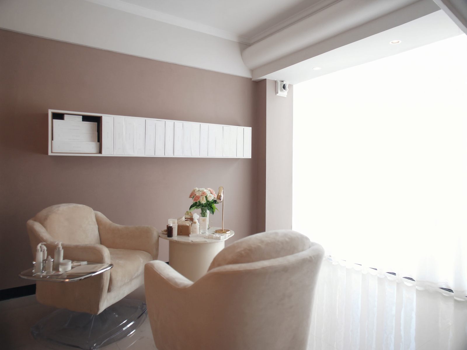 A consultation room with two armchairs and skincare bottles