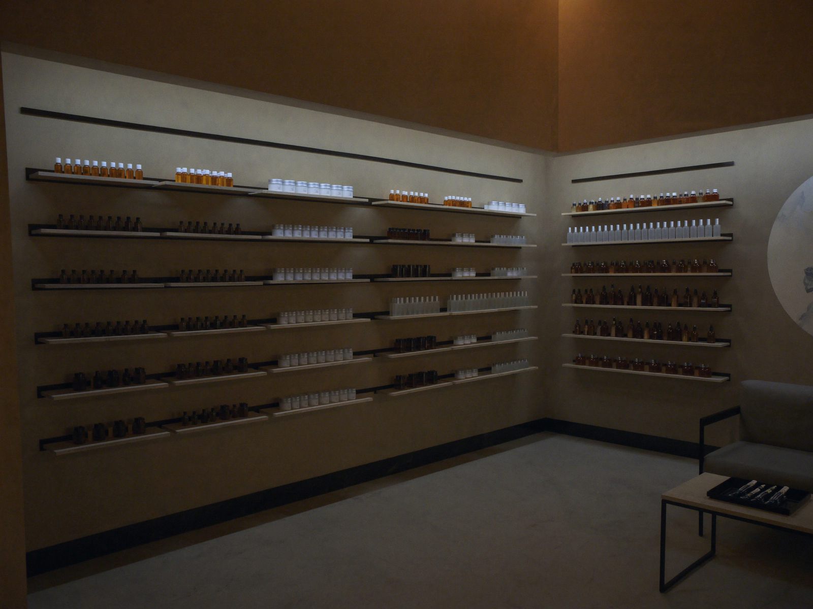 A med spa retail wall of skincare bottles on oak shelves