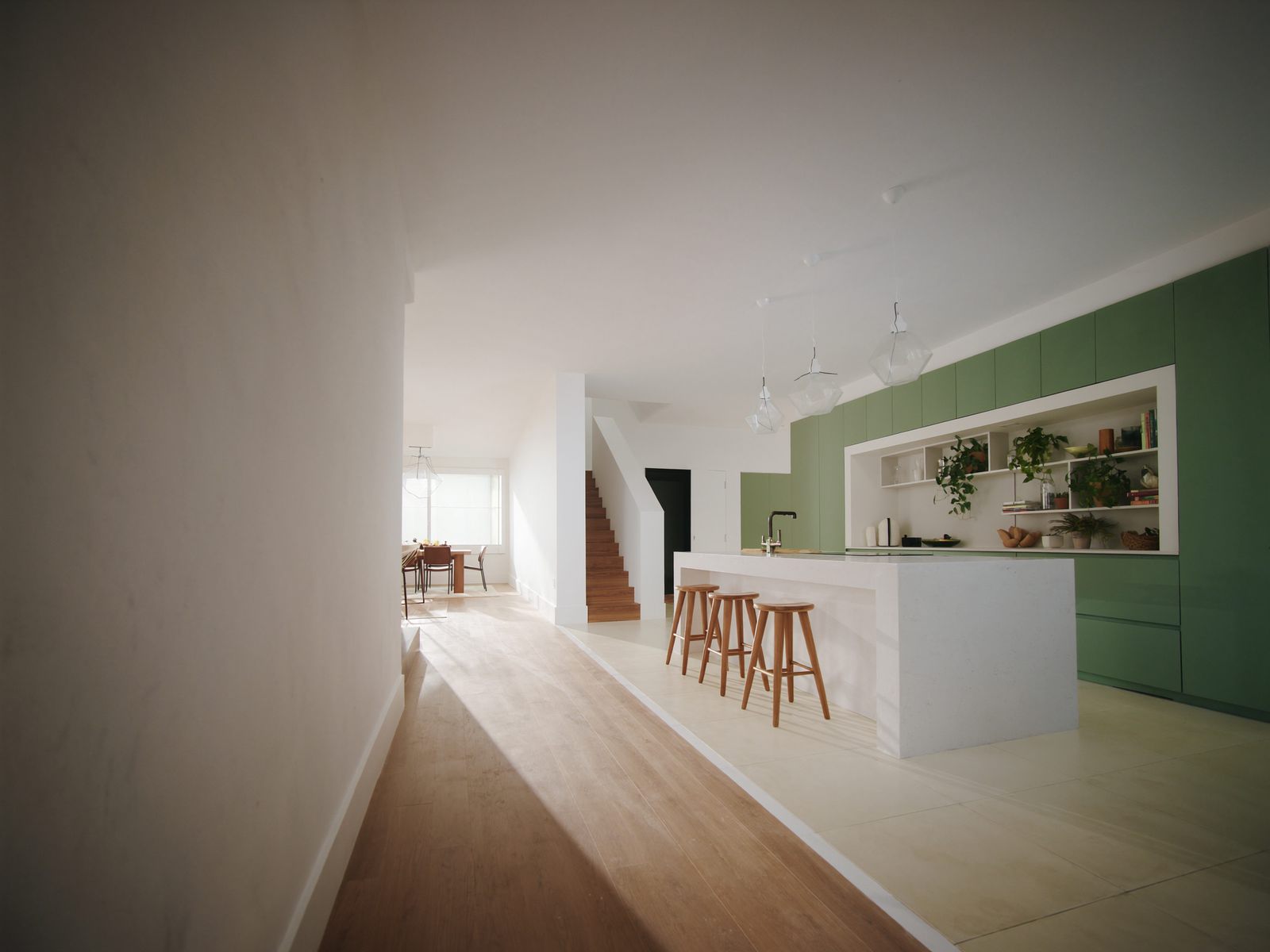 A staged kitchen with an island and pendant lights