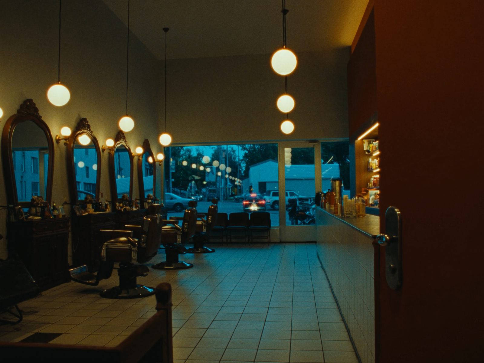 A barbershop at dusk with classic chairs and warm lights
